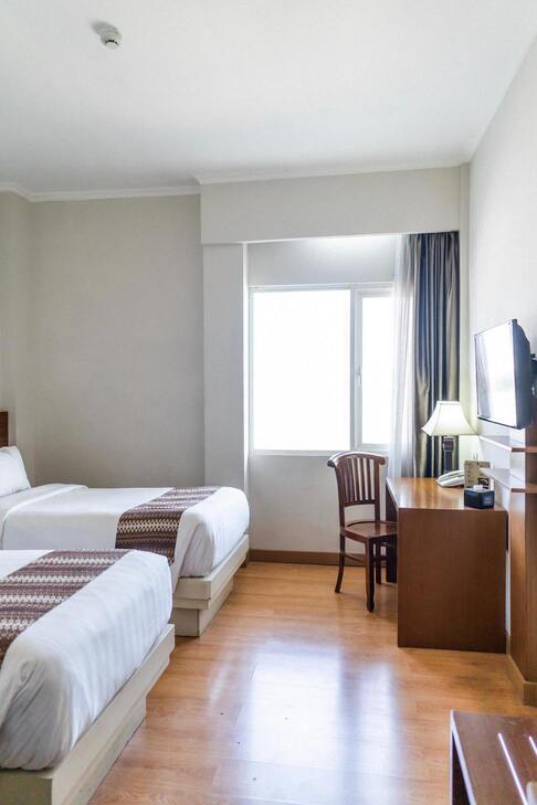 Hotel bed with desk and television